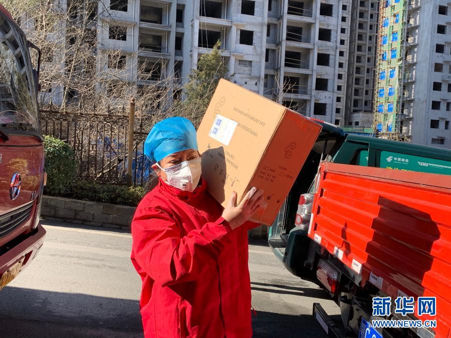 郑州圆方集团党委书记薛荣疫情期间在湖北省十堰市抗疫救灾指挥部后勤仓库搬运物资(资料照片)。新华社发