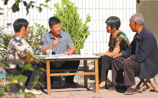 张建设(左二)在自家院子里为村民调解矛盾。