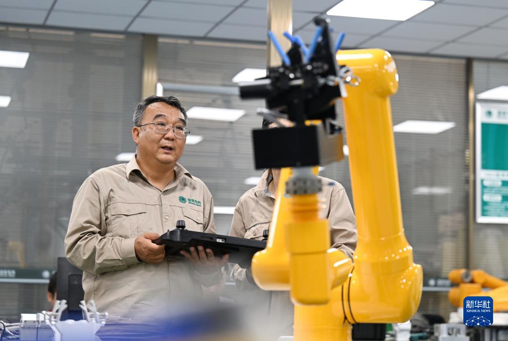 张黎明和同事在调试第四代配网带电作业机器人(2022年9月8日摄)。
